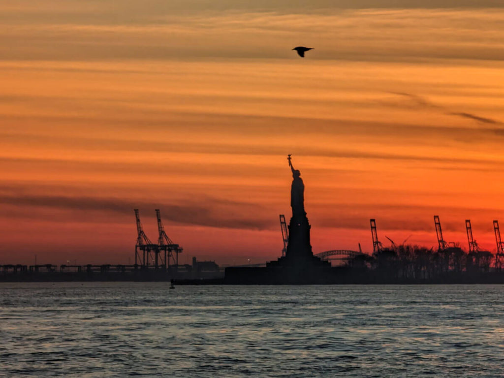 The Statue Of Liberty View From The Water At Sunset